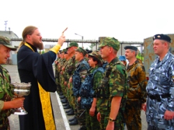Священник Александр Бачурин окропляет святой водой сотрудников милиции.